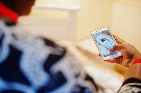 Close-up photo of a woman taking picture of a newborm african american baby.の写真素材