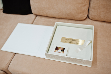 Awesome and elegant white box with wedding photobook or photo album inside laying on the sofa.の写真素材