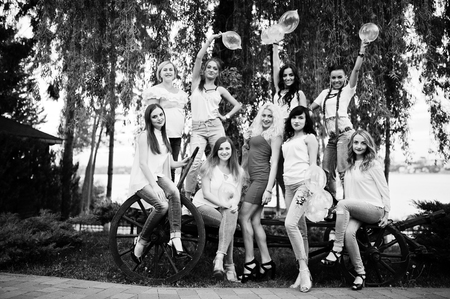 Comany of young women posing outside with inflated condoms at bachelorette party.の写真素材