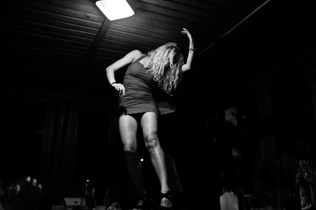 Young gorgeous bride in red dress dancing on the table at her bachelorette party.の写真素材