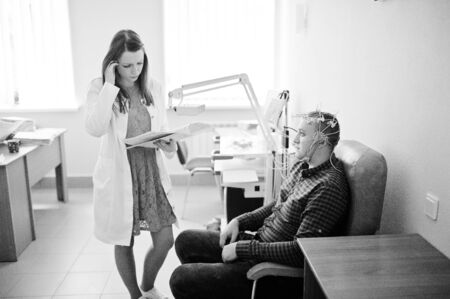 Attractive doctor in white coat examining her patient's health. Black and white photo.の写真素材