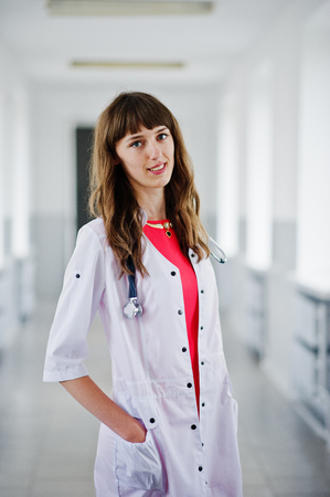 Portrait of a young attractive doctor in white coat with stethoscope posing in the hospital.の写真素材