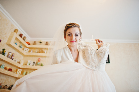 Portrait of a fantastic bride posing with her gorgeous white wedding dress.の写真素材