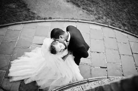 Amazing wedding couple kissing on the pavement. Black and white photo.の写真素材