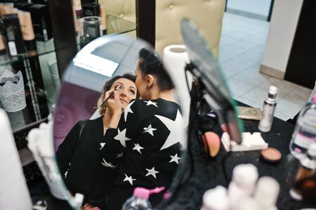 Gorgeous bride having her hair and makeup done in the beauty salon.