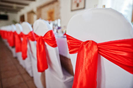 Gorgeously decorated chairs with red bows tied on themの写真素材