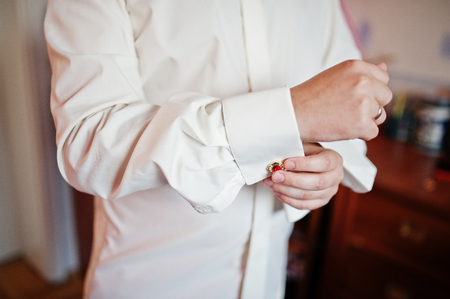 Handsome groom dressing up and getting ready for his wedding ceremony.の写真素材