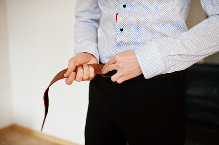 Portrait of a handsome groom dressing up and getting ready for his wedding.の写真素材