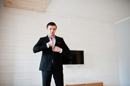 Portrait of a handsome groom dressing up and getting ready for his wedding.の写真素材