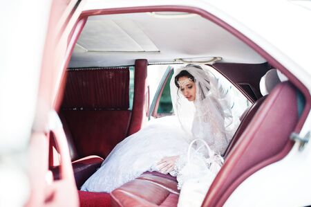 Flawless bride sitting in wedding car.の写真素材