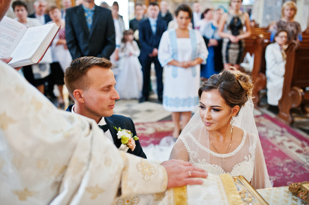 Intimate moment of a wedding couple making vows in the church during their wedding ceremony.の写真素材