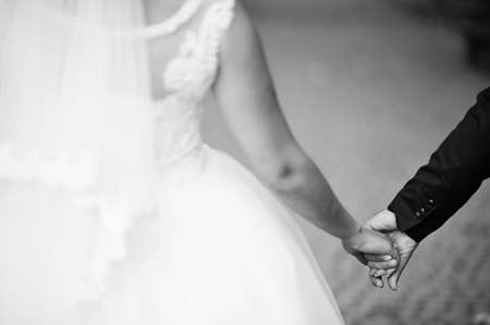 Close-up photo of a wedding couple holding hands. Black and white photo.の写真素材