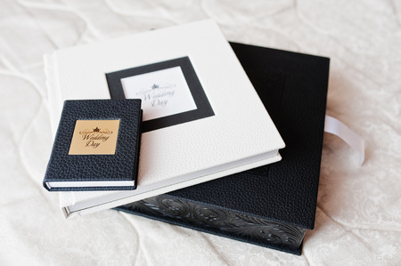 Elegant white and black wedding photobooks or photo albums on the white sofa.の写真素材