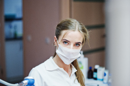 Portrait of a beautiful female dentist in a well-equipped cabinet.の写真素材