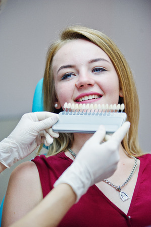 Talented female dentist figuring out what is the matching teeth color for her patient.の写真素材