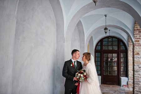 Fabulous wedding couple walking and posing next to the old building.の写真素材