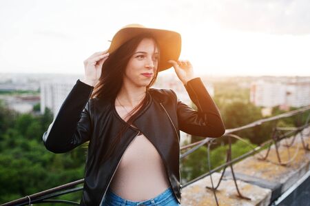 Portrait of a fabulous young woman in casual clothing posing with an orange hat.の写真素材