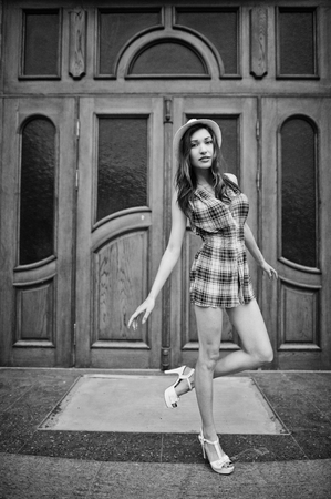 Amazing long legs with hig heels girl wear on hat posing against large wooden doors.の写真素材