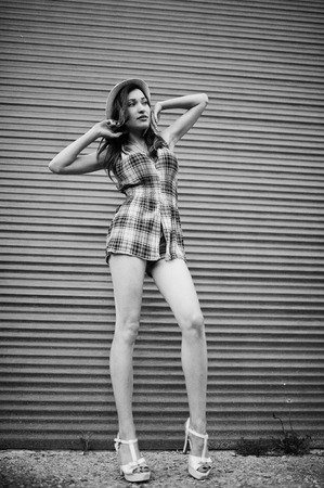 Amazing long legs with hig heels girl wear on hat against shutter.の写真素材