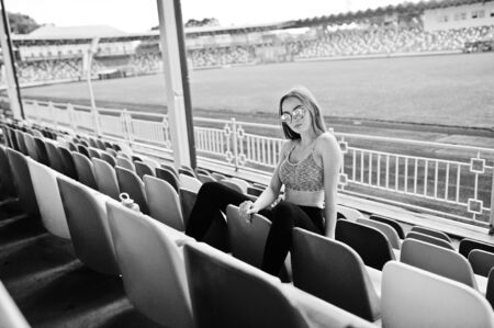 Fitness sporty girl in sportswear and sunglasses posed at stadium tribuneの写真素材