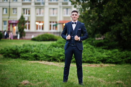 Portrait of a handsome young guy dressed in cool suit posing on the lawn on his prom day.の写真素材