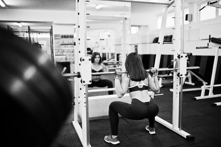 Young beautiful woman doing exercises  and working hard in gym and enjoying her training process.の写真素材