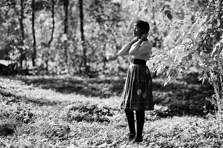 African american girl at yellow and red dress at autumn fall park.の写真素材