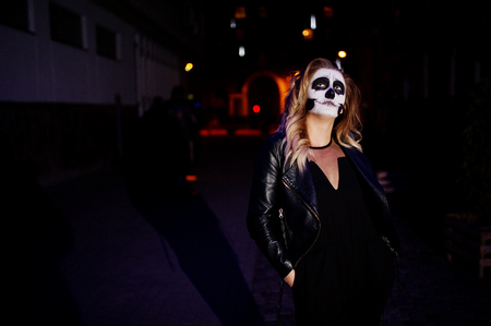 Halloween skull make up girl wear in black at night street of city.の写真素材