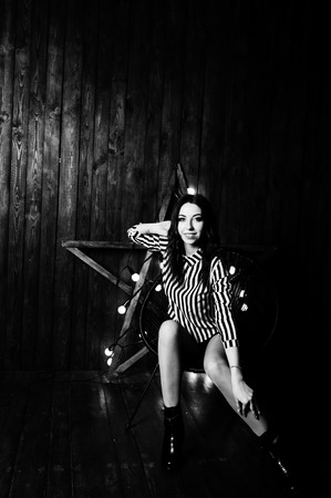 Girl posed against light star at studio with wooden background.の写真素材