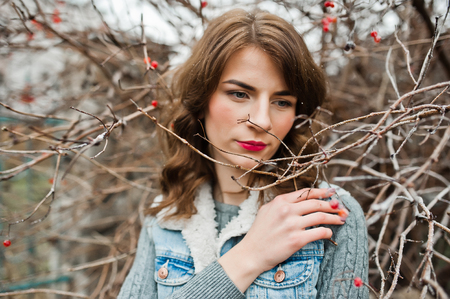 Portrait of brunette girl in jeans jacket at frozen bushes.の写真素材