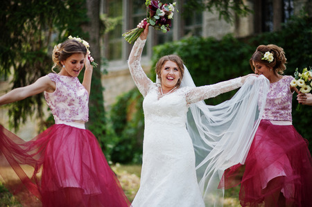 Happy bride and outgoing bridesmaids having fun on the wedding day next to a castle.の写真素材