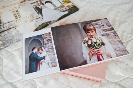 Pages with wedding photos of a photobook or photo album on bed.の写真素材