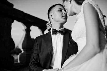Romantic wedding couple sitting on the stairs next to the castle. Black and white photo.の写真素材