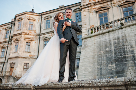 Fabulous wedding couple walking around the castle territory on their festive day.の写真素材