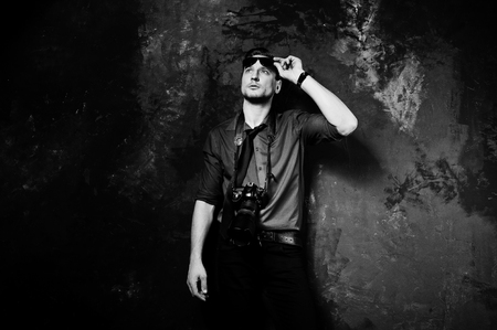 Studio portrait of stylish professional photographer man with camera, wear on blue shirt and necktie, sunglasses.の写真素材