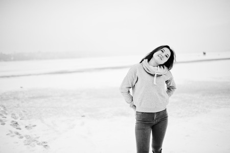 Funny girl wear on hoody sweater and jeans, at frozen lake in winter day.の写真素材