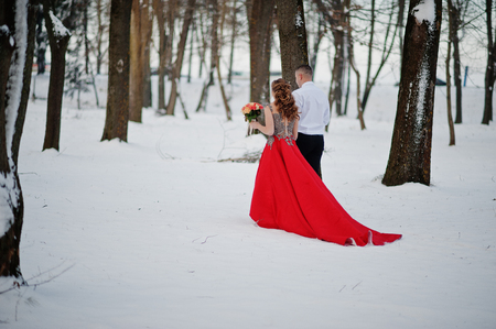 Amazing couple in winter fairytale forest in love. Girl in red beautiful dress. Valentine's Day theme.の写真素材