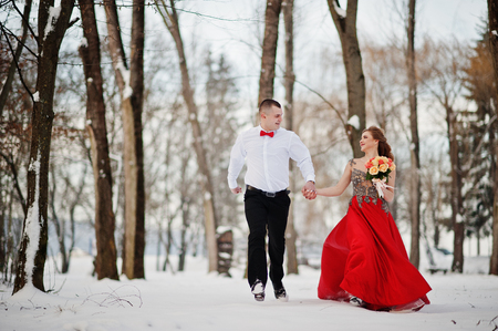 Amazing couple in winter fairytale forest in love. Girl in red beautiful dress. Valentine's Day theme.の写真素材