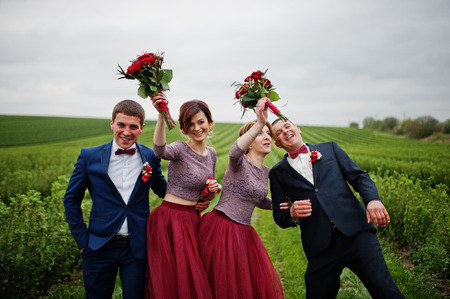 Groomsmen and bridesmaids having fun and posing in blacckcurrant field.の写真素材