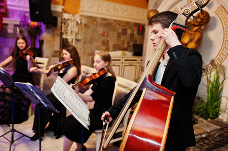 String quartet playing instruments in the restaurant on the wedding party.の写真素材