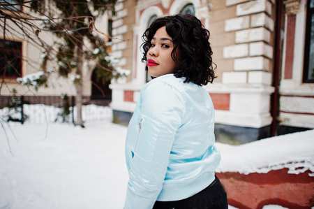 Stylish african american plus size model at streets of city on winter day.の写真素材
