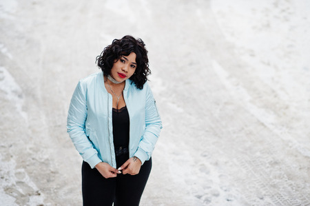 Stylish african american plus size model at streets of city on winter day.の写真素材
