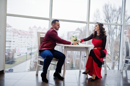 Couple in red love each other at restaurant indoor.の写真素材