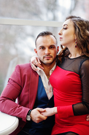 Couple in red love each other at restaurant indoor.の写真素材