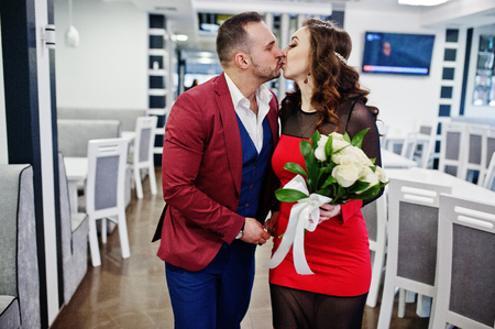 Couple in red love each other at restaurant indoor.の写真素材
