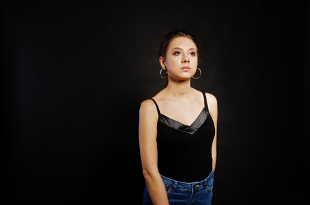 Studio portrait of brunette girl with make up on black background.の写真素材