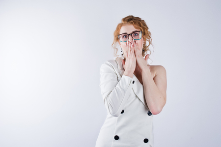 Curly hair girl astonished face in glasses isolated on white studio background.の写真素材