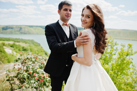 Wedding couple at breathtaking landscape with rock and lake.の写真素材