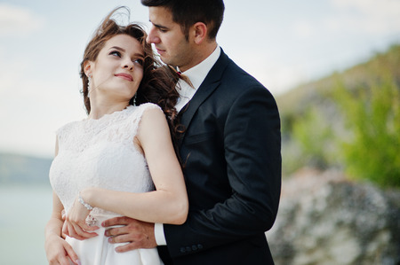 Wedding couple at breathtaking landscape with rock and lake.の写真素材