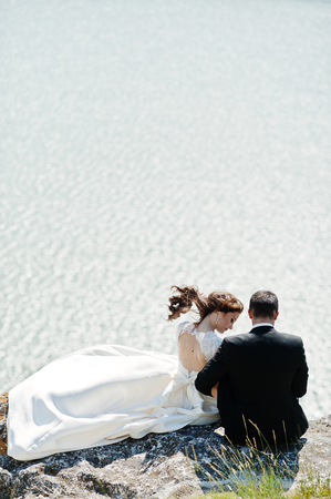Wedding couple at breathtaking landscape with rock and lake.の写真素材